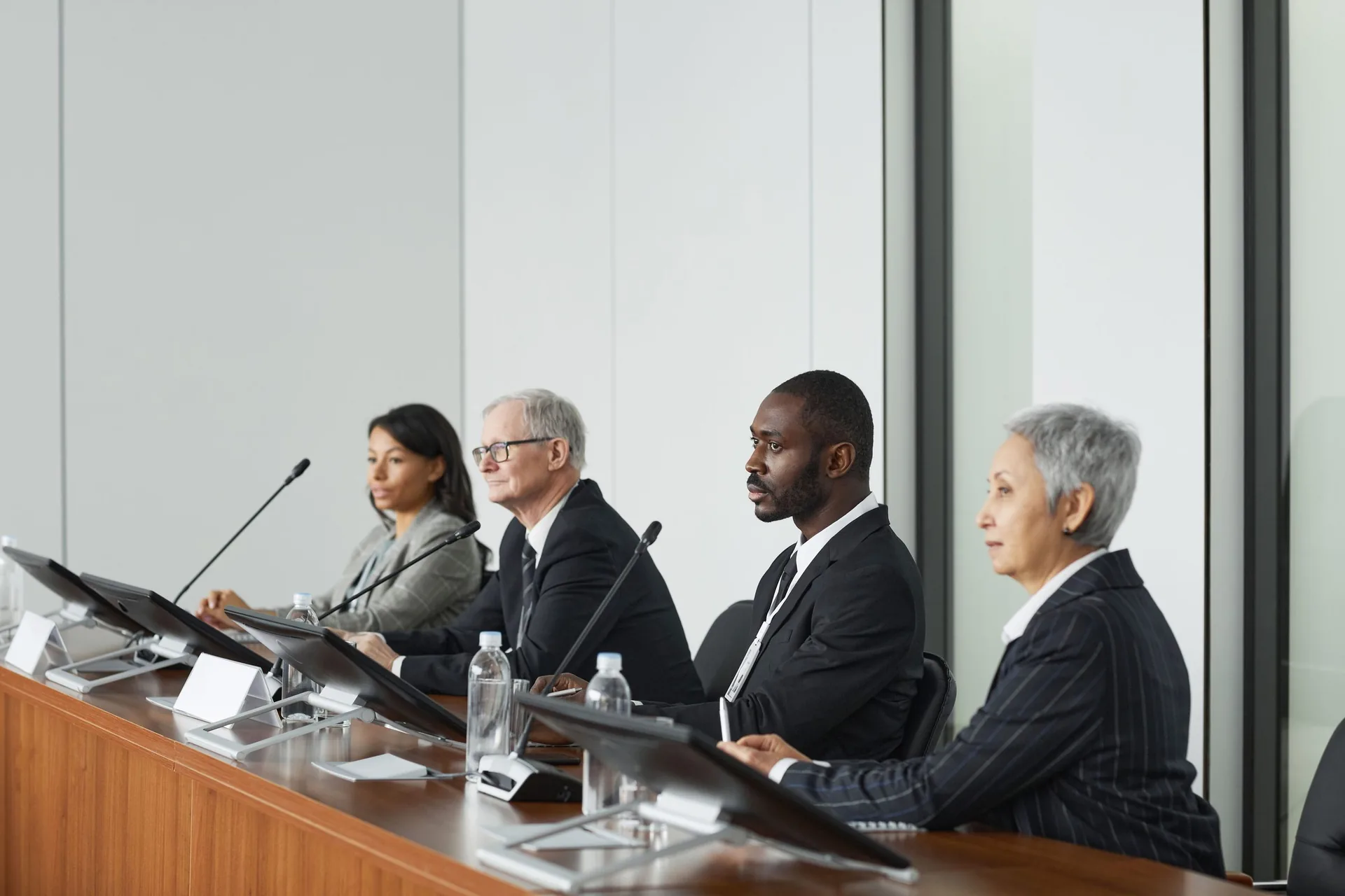 Executives seated at a boardroom table during a panel meeting