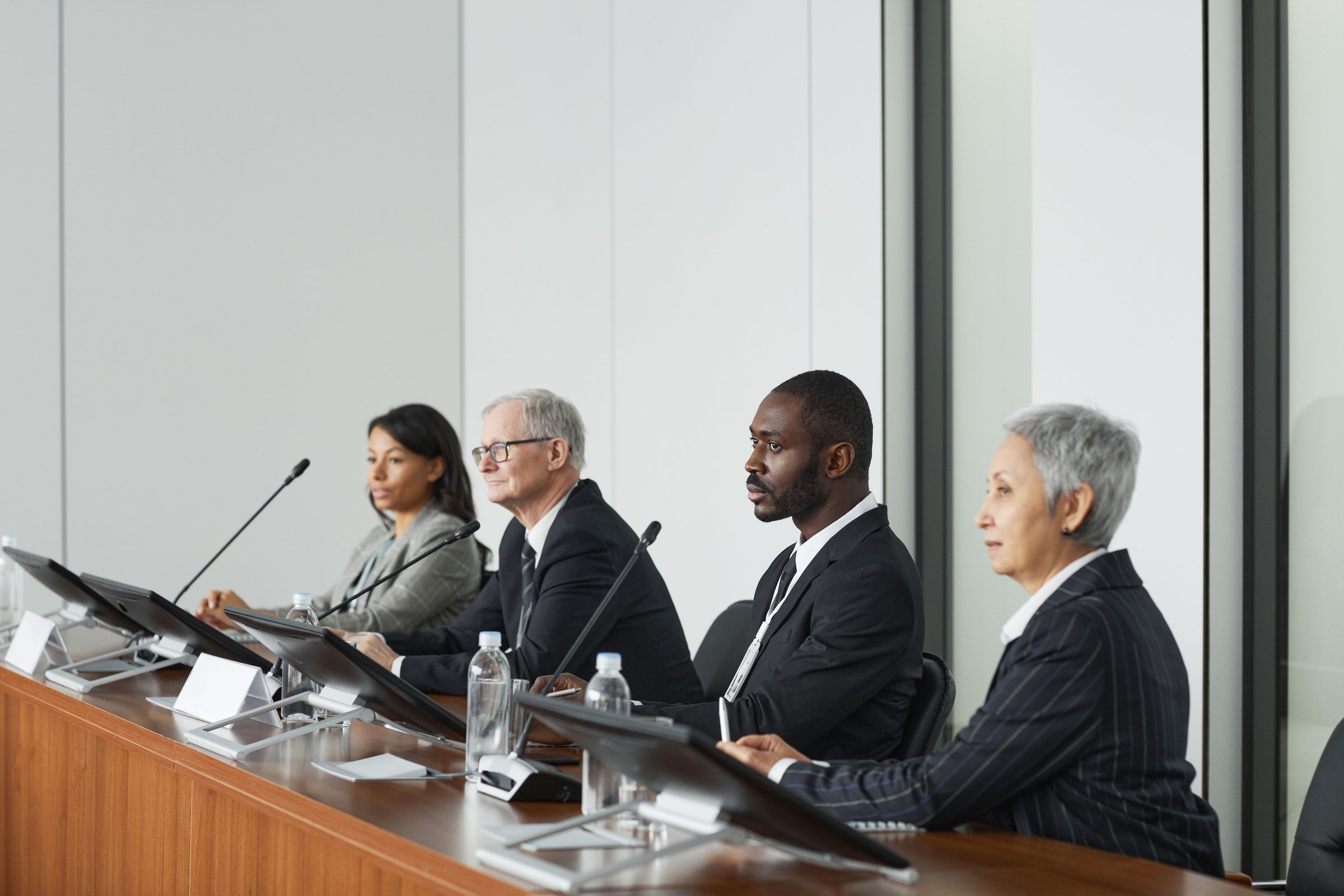 Executives seated at a boardroom table during a panel meeting